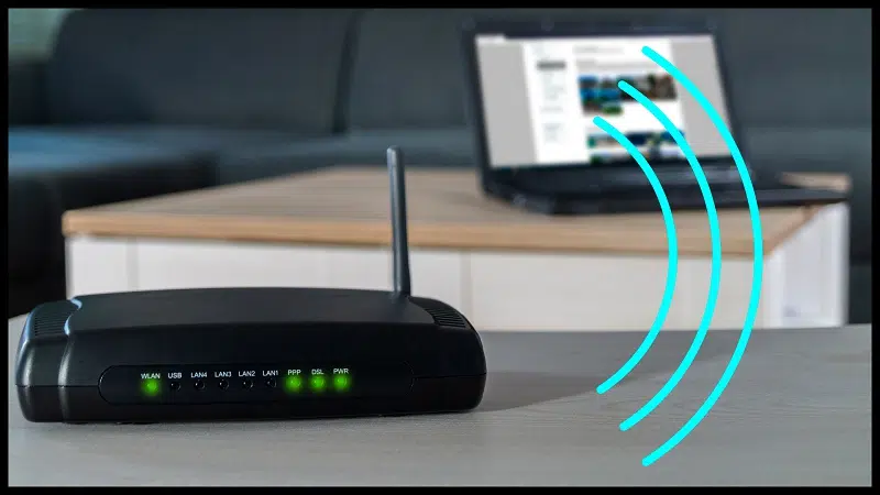 Wifi router with lights and computer in background with radio waves